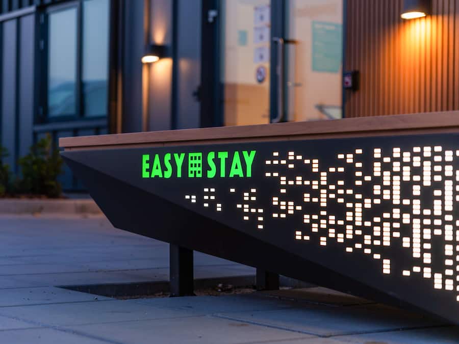Un panel digital con el texto 'EASY STAY' en un banco.