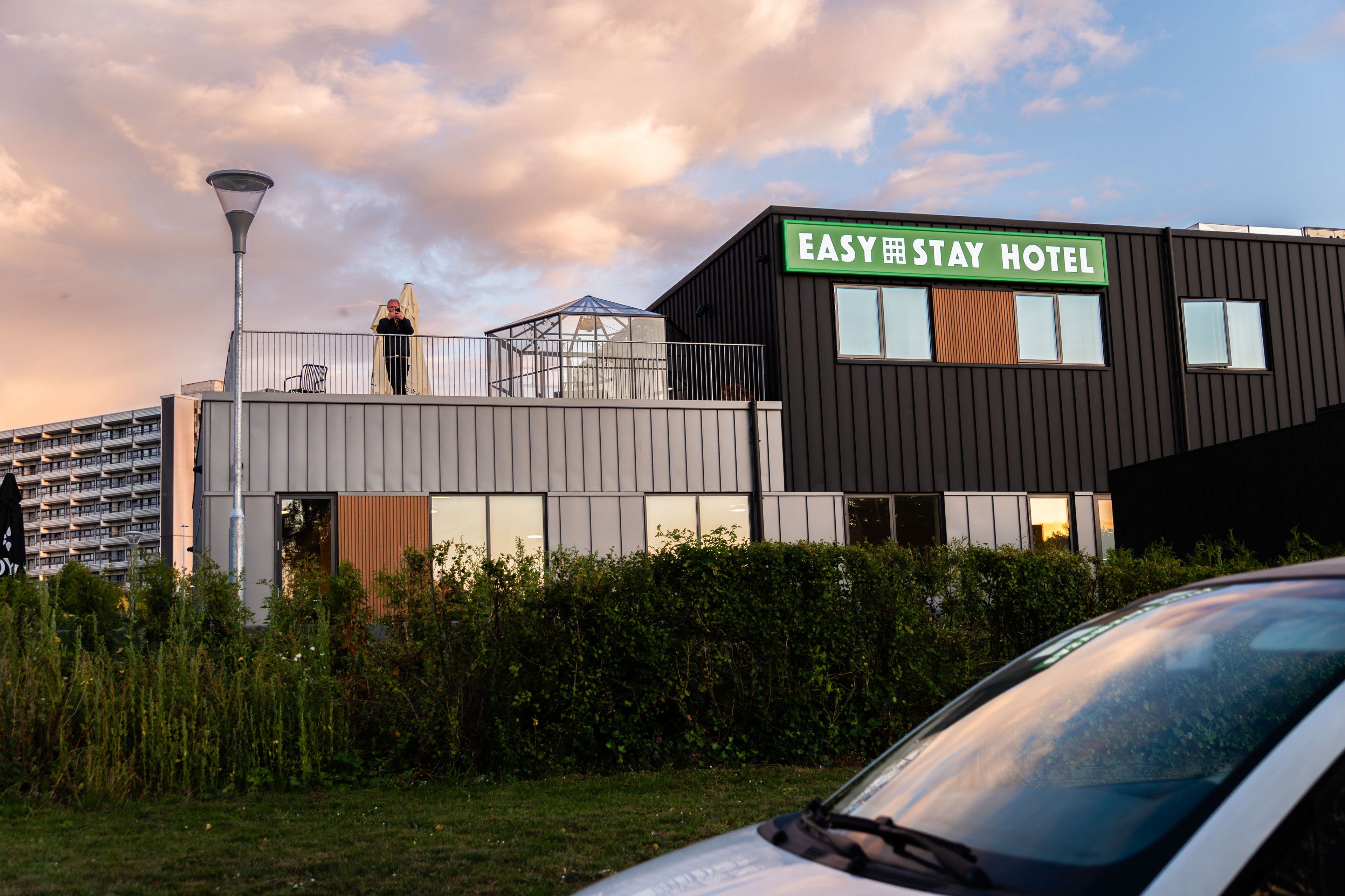 A modern hotel building with a sign reading 'EASY STAY HOTEL.'