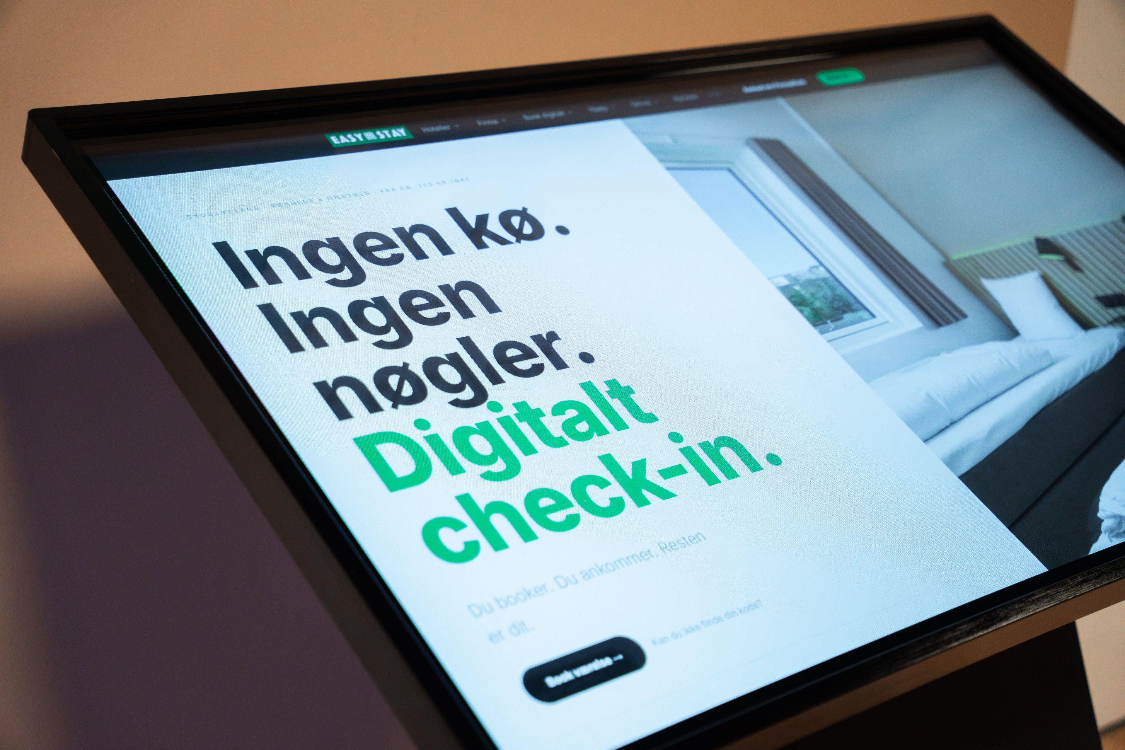 Un display digitale con testo in lingua straniera, probabilmente relativo ai servizi o alle dotazioni di un hotel.