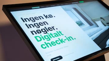 Un display digitale con testo in lingua straniera, probabilmente relativo ai servizi o alle dotazioni di un hotel.