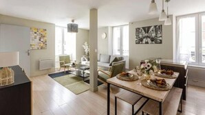 A modern apartment with a dining area, a living room, and a kitchen. - Cocon du Château - Elegant T3 in the historic heart of Vizille (Vizille)