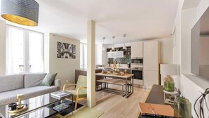 A modern apartment with a living area, dining space, and kitchen. - Cocon du Château - Elegant T3 in the historic heart of Vizille (Vizille)