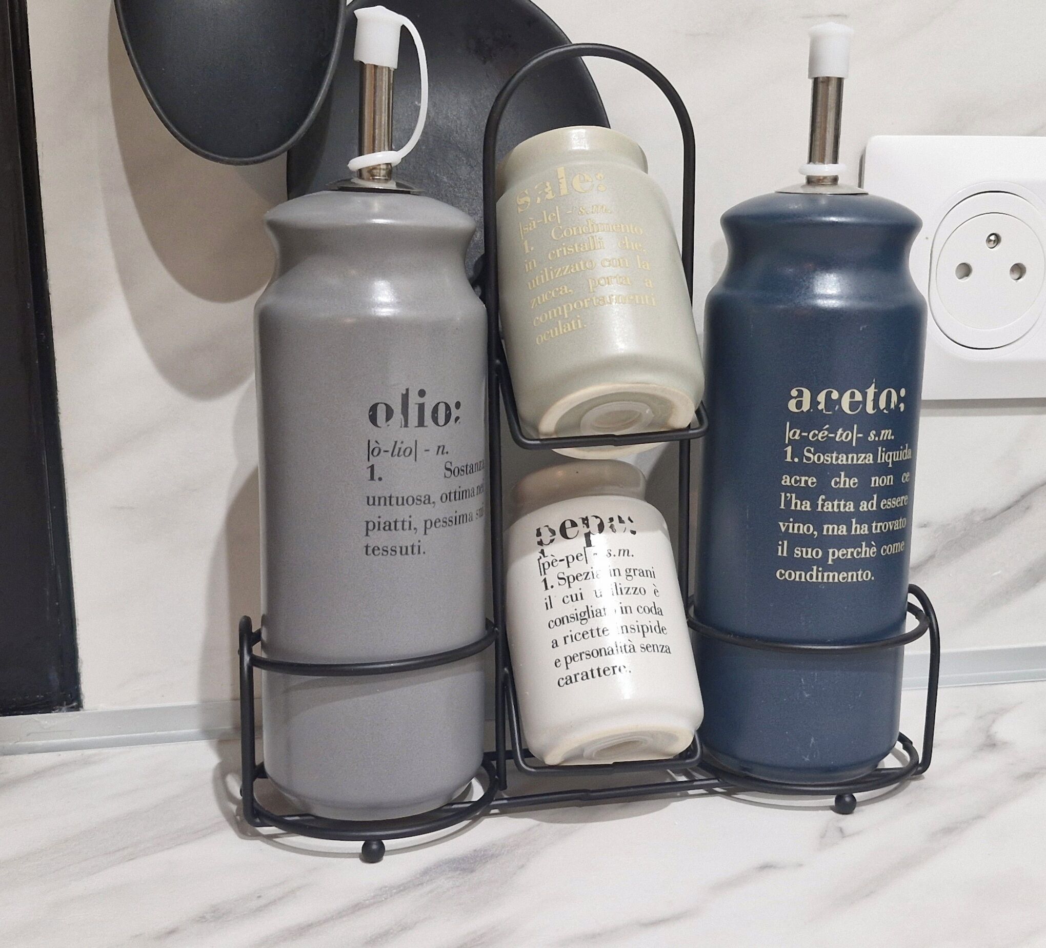 A set of three containers with Italian text on a kitchen counter.