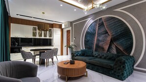 A modern living room with a round coffee table, a sofa, and a dining area with chairs. - DUBROVNIK VISTA RESIDENCE by DuHomes  (Dubrovnik)