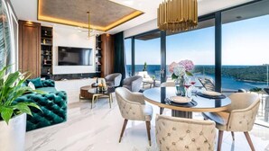 A modern living room with a large TV, comfortable seating, a dining area, and a view of the sea. - DUBROVNIK VISTA RESIDENCE by DuHomes  (Dubrovnik)