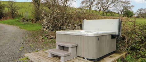 A hot tub on a wooden platform in a natural setting.
