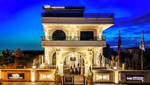 A hotel with a rooftop terrace, a balcony, and a sign indicating an electric charging area. - White Mansion Cappadocia (Nevşehir)