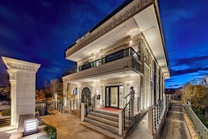 A grand, two-story building with a balcony, a staircase, and a well-lit entrance. - White Mansion Cappadocia (Nevşehir)