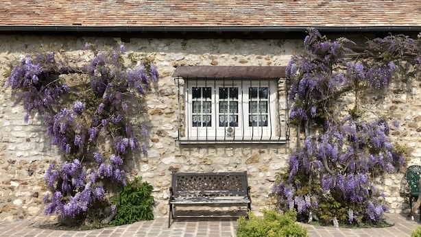 Un bâtiment en pierre avec une fenêtre et un banc devant.