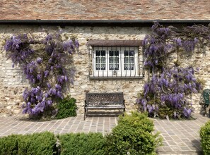 Un bâtiment en pierre avec une fenêtre et un banc devant.
