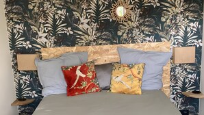 Un lit avec une tête de lit, des oreillers et une table de chevet.