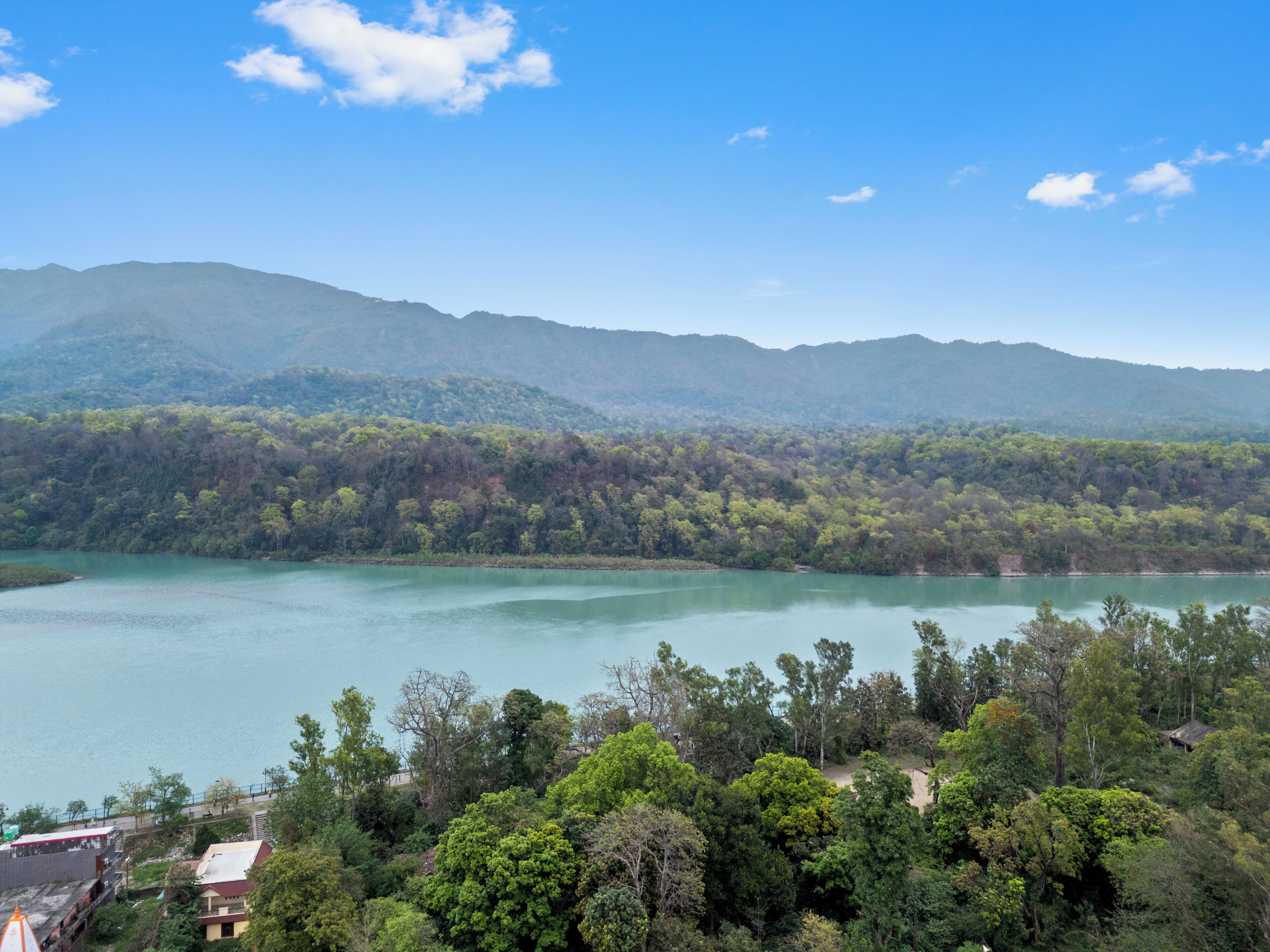 A lake surrounded by dense forest and mountains.