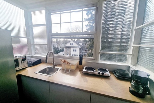 Step into a well-appointed kitchen designed for convenience. It includes a full-sized refrigerator, range, space for meal prep, and dining table. You'll find generous storage in the cabinetry, making it easy to keep things organized.