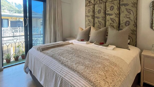 Un dormitorio con una cama grande, vistas a un balcón y un cabecero decorativo.