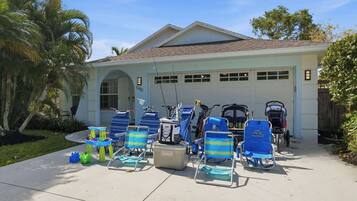 A house with a garage, outdoor seating with chairs and a table, and a pool.