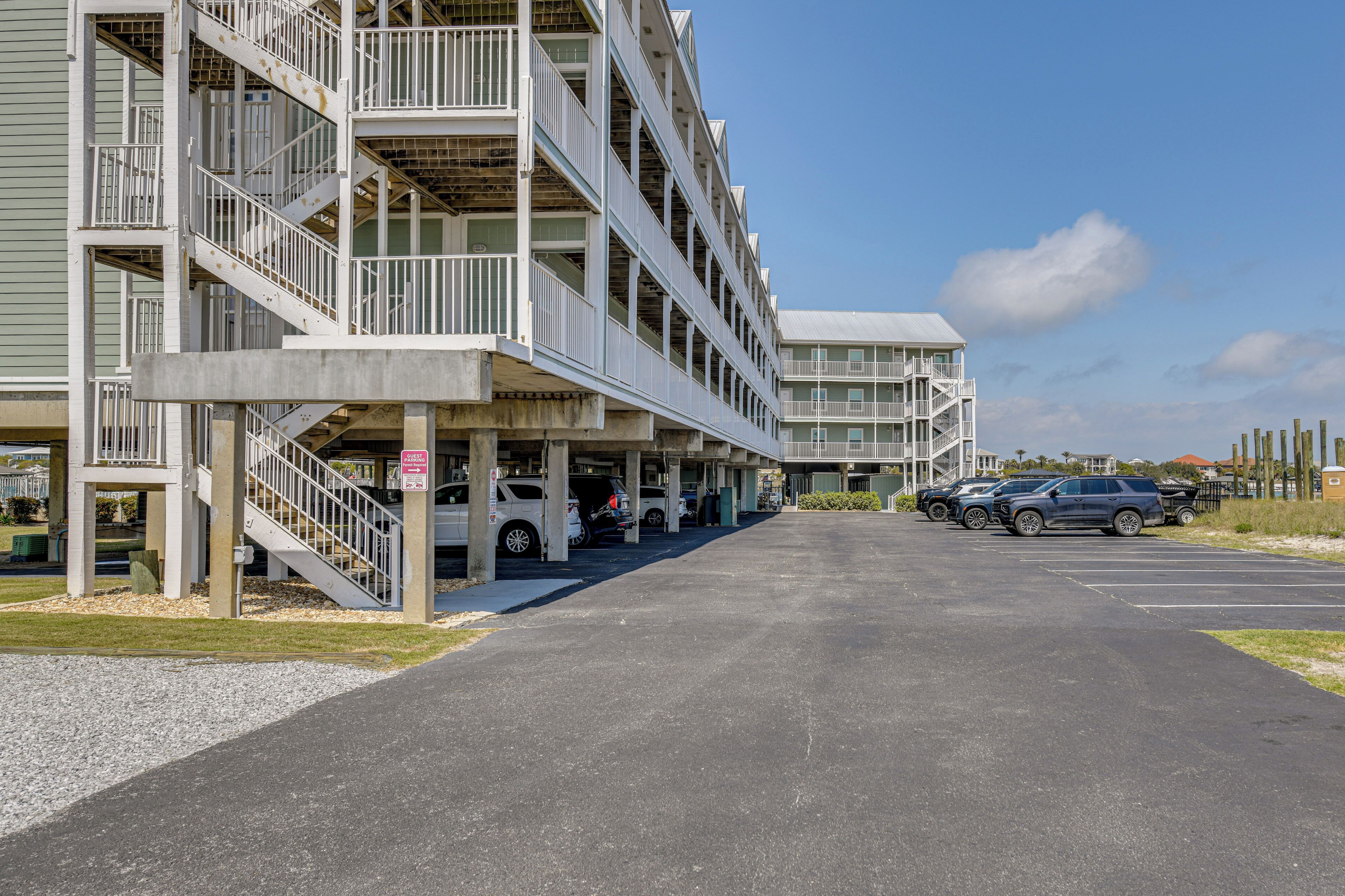 Un parking à plusieurs étages, doté d’une passerelle couverte et d’un immeuble avec des balcons.
