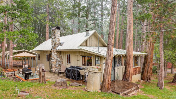 A rustic cabin with a stone chimney, a covered patio, and a grill area. - Gateway to Sequoia Natl! Rustic Cabin w/ Patio (Camp Nelson)