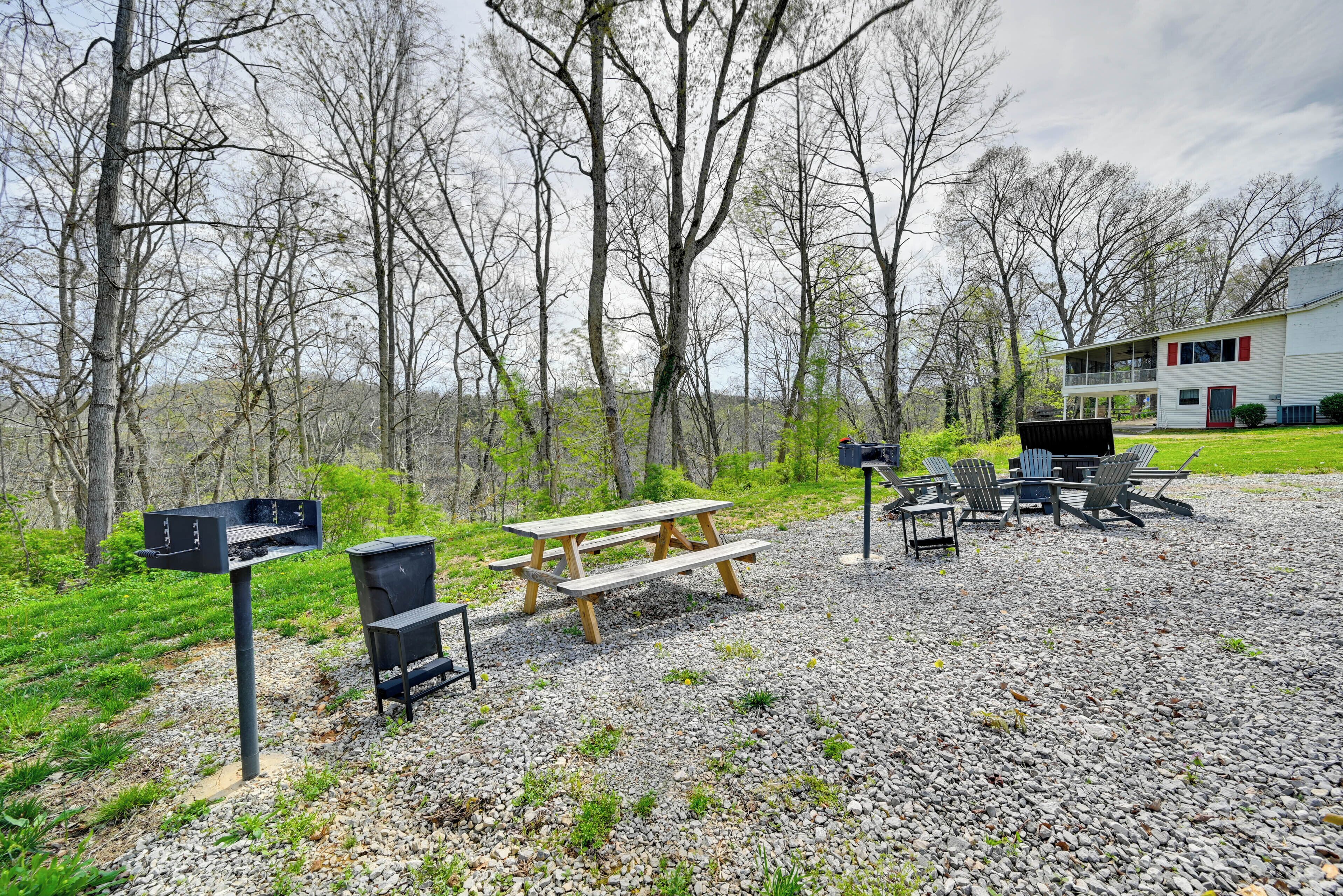 A picnic area with a grill, benches, and outdoor seating.