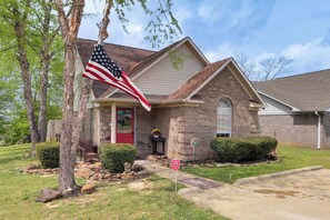 A house with a brick exterior, a red door, and an American flag.