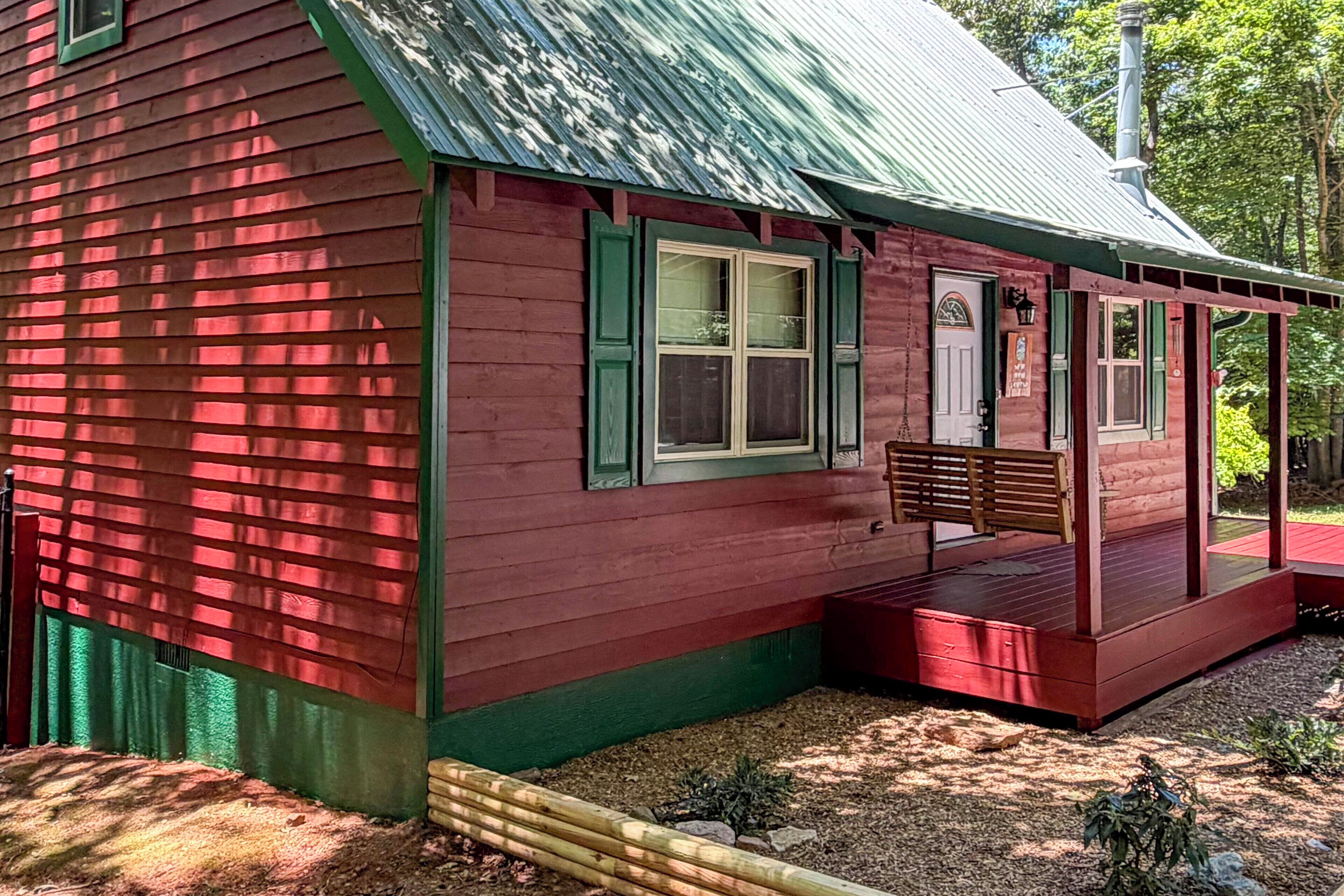 Un petit bâtiment en bois d’un seul étage, doté d’un toit vert et d’un porche.