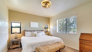 A bedroom with a bed, bedside lamps, a dresser, a bench, and a window with blinds. - Walk to Private Lake! Family Cabin w/ Large Decks (Show Low)