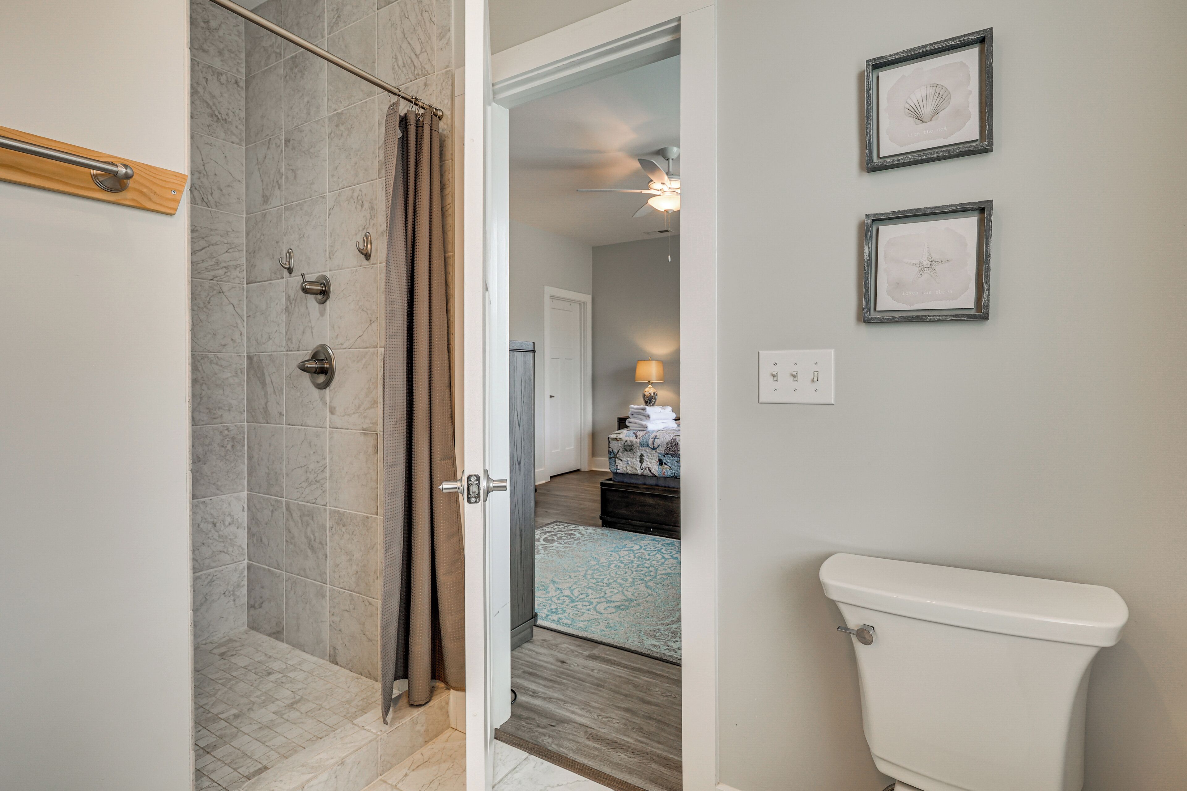 Un bagno con doccia, toilette e un quadro appeso alla parete.