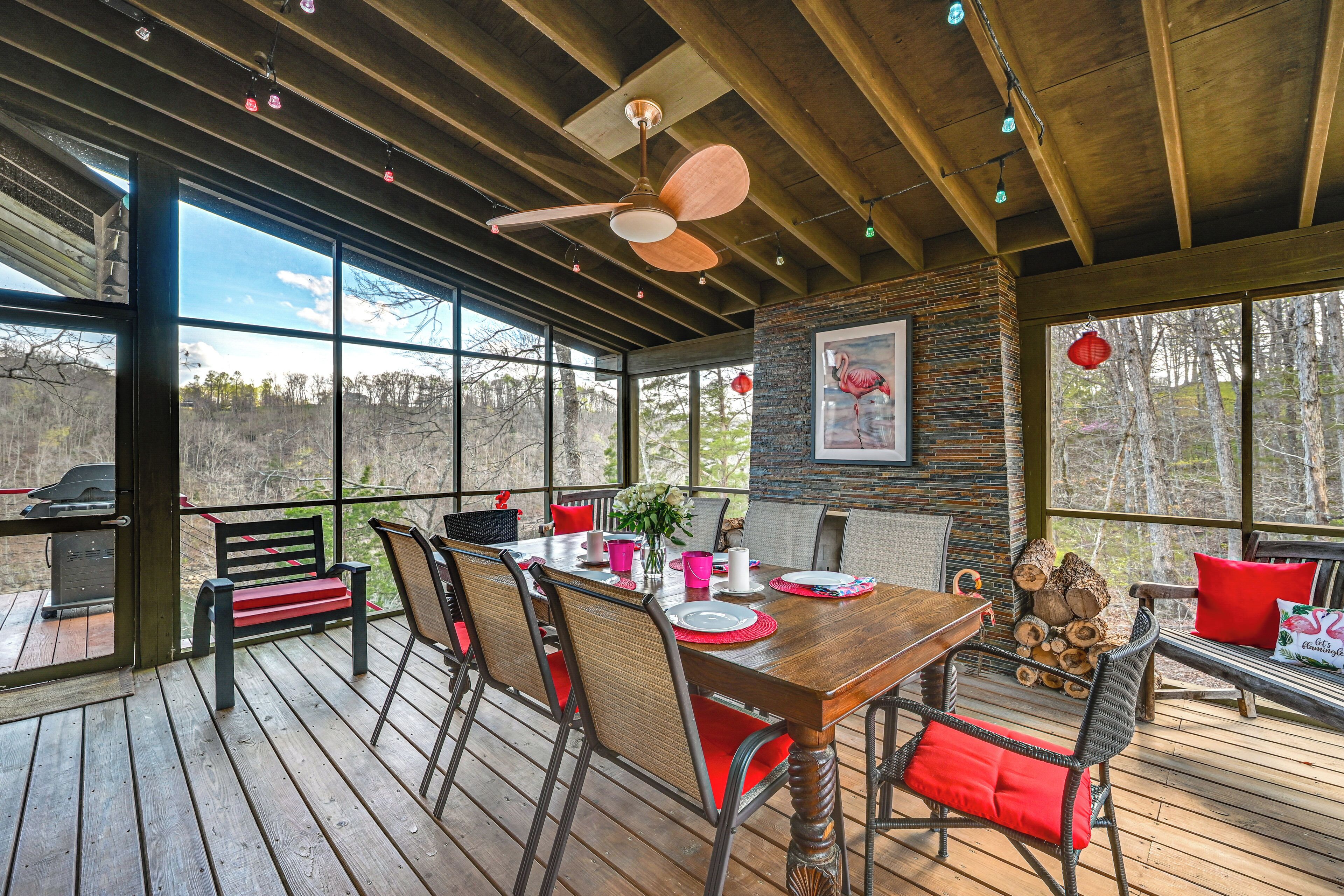 Una terraza de madera con una mesa de comedor, sillas y un ventilador de techo.