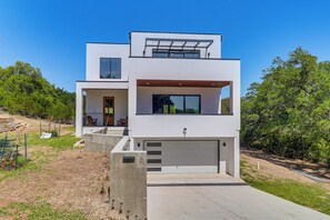 A modern two-story house with a garage, a balcony, and a small outdoor seating area. - Walk to Lake Travis & Parks! Resort-style Getaway (Leander)