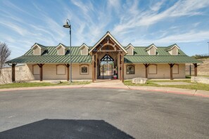 A building with a green roof, a central entrance, and a bell tower.