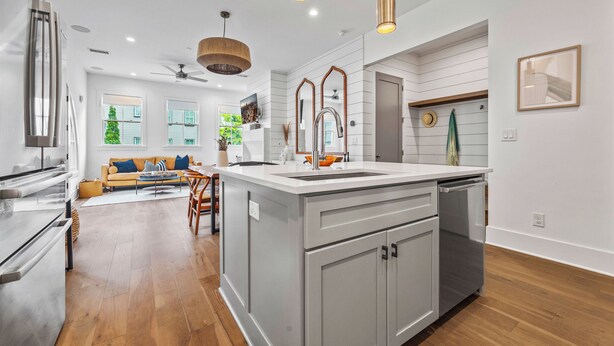 A modern kitchen with a central island, stainless steel appliances, and pendant lighting. - Luxury home in Trilith steps from US Soccer Center, Pool, and Restaurants (Fayetteville)