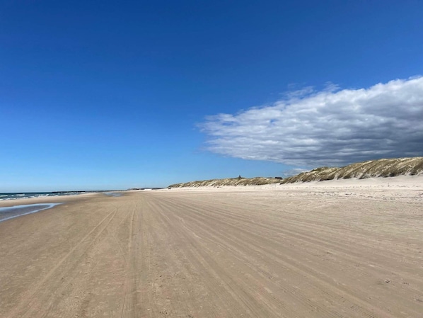 A wide sandy beach with dunes in the background and a clear sky. - 4 Star Holiday Home in Lokken (Lokken)
