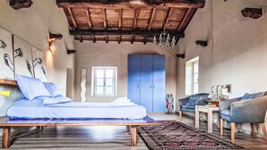 Une chambre à coucher comprenant un lit, un bureau, une chaise, une armoire et un lustre.