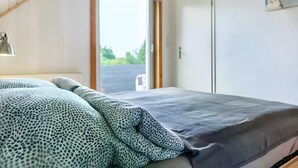 Une chambre à coucher avec un lit, une fenêtre et une porte.