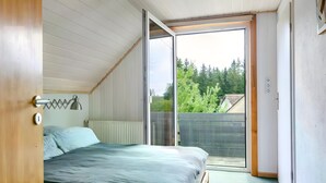 Une chambre à coucher avec un lit, un radiateur, une fenêtre et une porte.