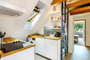 Eine moderne Küche mit eingebautem Herd, einer Spüle und einem Fenster über der Arbeitsfläche.
