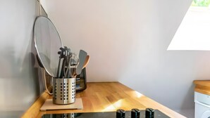 Un coin cuisine comprenant une cuisinière, un évier, un miroir et un porte-ustensiles.