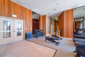 A gym with exercise equipment, a rack of dumbbells, and a treadmill. - Sleek Studio - Balcony - Near FIFA Fan Fest (Miami)