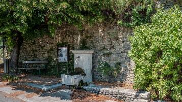 Un muro de piedra con un banco y un cartel.