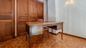 Une pièce avec un plancher en bois, un bureau doté de tiroirs et une armoire avec une poignée de porte.