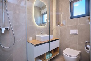 A modern bathroom with a glass-enclosed shower, a white sink, and a toilet. - Ray Holiday Apartment (Okrug Gornji)