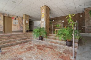 A lobby with marble flooring, a staircase, and potted plants. - Apartment 'Beach Front Home A125' with Sea View, Wi-Fi and Air Conditioning (Torrox Costa)
