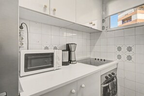 A kitchenette with a microwave, coffee maker, and gas stove. - Apartment 'Beach Front Home A125' with Sea View, Wi-Fi and Air Conditioning (Torrox Costa)
