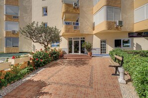 A building with a tiled entrance, a small tree, and a bench. - Apartment 'Beach Front Home A125' with Sea View, Wi-Fi and Air Conditioning (Torrox Costa)