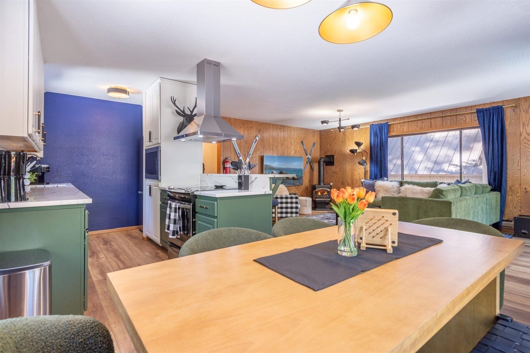 Un espace de vie compact comprenant un coin cuisine, un coin repas et un espace détente avec vue.