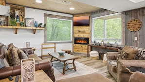 Una sala de estar acogedora con chimenea, estanterías de madera, un sofá y una mesa de centro.