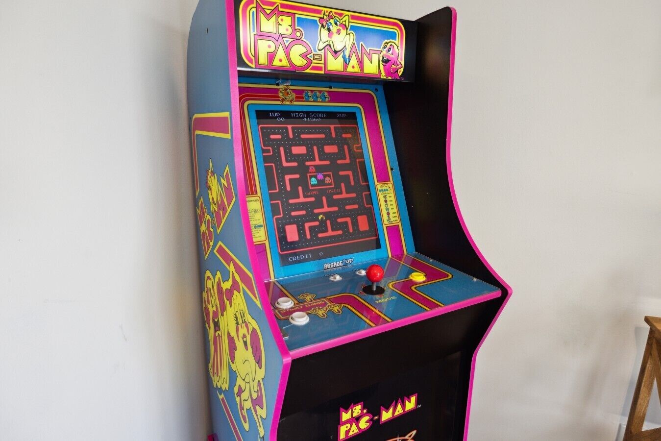 Een oud aangeschreven spelautomaat voor een doolhofspel, met een scorebord en een joystick.