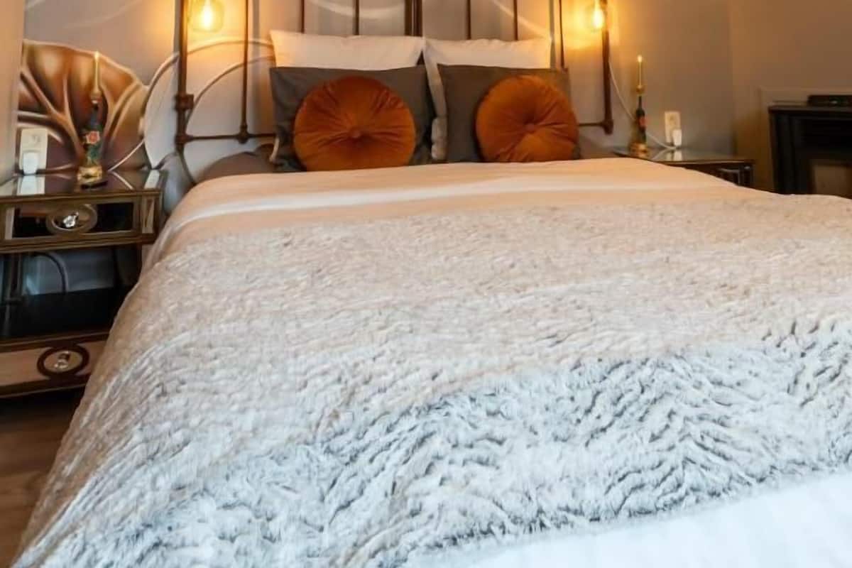 Un dormitorio con cama, decoración mural y una araña.
