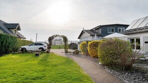Un quartier résidentiel avec des maisons, une allée pavée et une voiture blanche garée dans la cour.