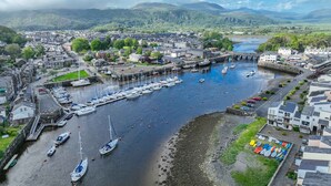 A harbor with boats, a bridge, and buildings along the waterfront. - Beautifully Converted Workshop Close to the Beach | Gweithdy-Bronafon (Borth y Gest)