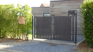 A gated property with a wooden fence, a sign, and a building with a window and a number. - Chalet 'Le Ch'ti  Lecelles' with Private Terrace and Private Garden (Lecelles)